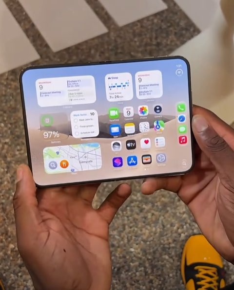 Two hands hold a foldable smartphone displaying an iOS home screen with a 97% battery widget and various app icons.