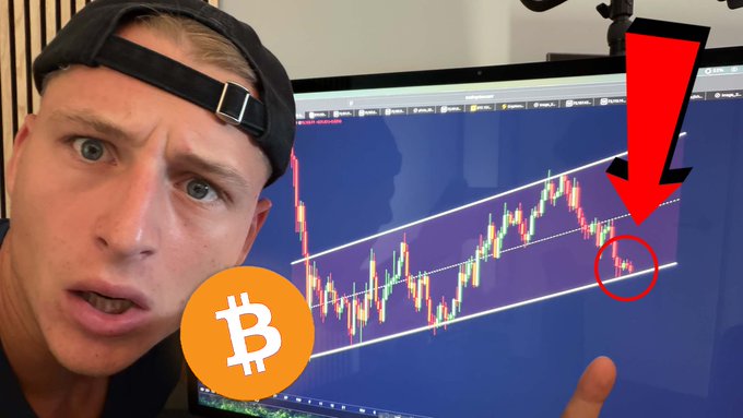 The image features a man wearing a hat, standing next to a computer monitor displaying a stock chart of Bitcoin prices. The computer screen shows a series of ticks representing the changes in the Bitcoin price over time. In the background, there's a close-up of a Bitcoin symbol on the screen. A caption below the graph reads: "BIG #BITCOIN SQUEEZE IMMINENT!!! (here is why) Watch NOW: youtu.be/_iNq3MzLPi0". This sentence explains what the chart is showing, which is an increase in Bitcoin prices over time. The image shows that something has occurred that caused a sudden surge in Bitcoin values, making it a significant moment for Bitcoin enthusiasts and investors to watch and analyze closely.