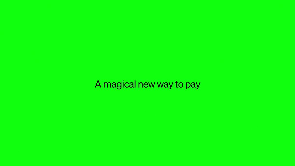 The image features a green square with white text that reads "A magical new way to pay". The background of the image is a light gray color. There are no other objects or texts present in the image, making it a simple and clean layout.