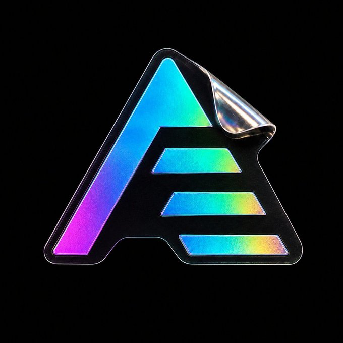 A holographic, iridescent sticker shaped like the letter "A" is shown peeling at its corner against a black background.