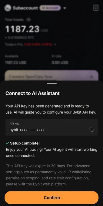 The image shows a cell phone screen displaying an app called "Bybit AI Sub Account" that provides assistance for better trading management by connecting to an AI key, which helps users track their trading strategies more effectively. The app enables traders to manage multiple accounts using one centralized API, making it easier to monitor and analyze performance across various platforms. This technology can help traders improve their trading results by providing valuable insights into the strategies that have been implemented in different account settings.
