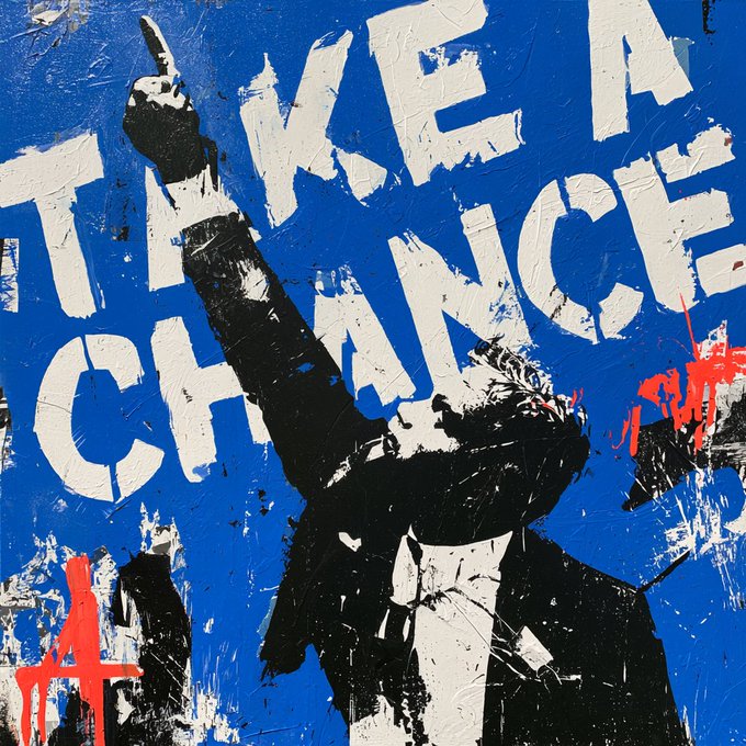 A stylized stencil painting features a black silhouette of a man raising a pointed finger in front of bold white text reading "TAKE A CHANCE" against a blue background, with red paint splatters adding rebellious flair—visually reinforcing the post's call to join the Discord community.