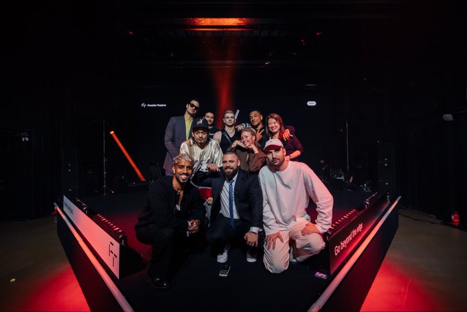 A group of nine people pose together behind a Solana-branded trading desk, with visible text including "Go beyond the limit" and "FT" on the illuminated counter, capturing a celebratory moment that reflects the post's emphasis on creating forward-thinking experiences with the Solana community.
