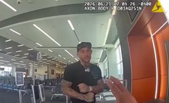 A dashcam or security camera view showing a bearded man in a black shirt gesturing with his hands in what appears to be a parking garage, with timestamp "2025-06-21" visible.