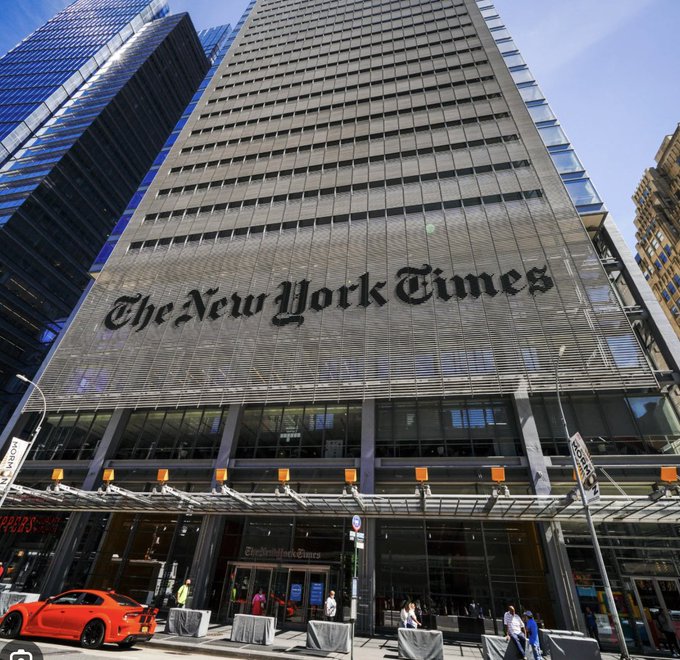 The New York Times Building displays its iconic gothic-style logo on a towering glass facade, with pedestrians walking near the entrance below. The image relates to the post's claim by depicting The New York Times, which is referenced in the post's characterization of "FAKE NEWS networks."