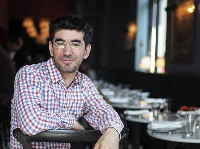 A man in a checkered shirt sits at a restaurant table, smiling at the camera in what appears to be a casual dining setting.

Note: There is no visible text, numbers, tickers, or names in the image, and the image does not appear to directly relate to the post about Pi App Studio or app development infrastructure. The image simply shows a person in a restaurant environment, which seems unrelated to the content of the accompanying post.