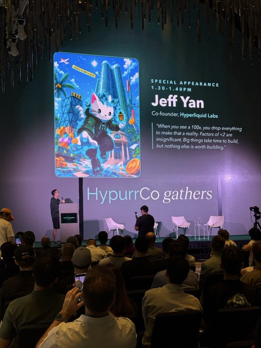 A conference stage with a large screen displaying a special appearance announcement for Jeff Yan, Co-founder of Hyperliquid Labs, featuring an anthropomorphic cat mascot and the text 'HypurrCo gathers'.
