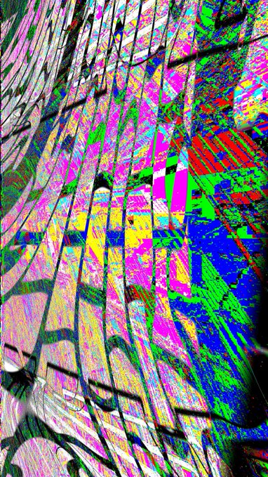 A heavily distorted, glitch-art style image with vibrant magenta, green, blue, and yellow colors forming abstract vertical and diagonal patterns.