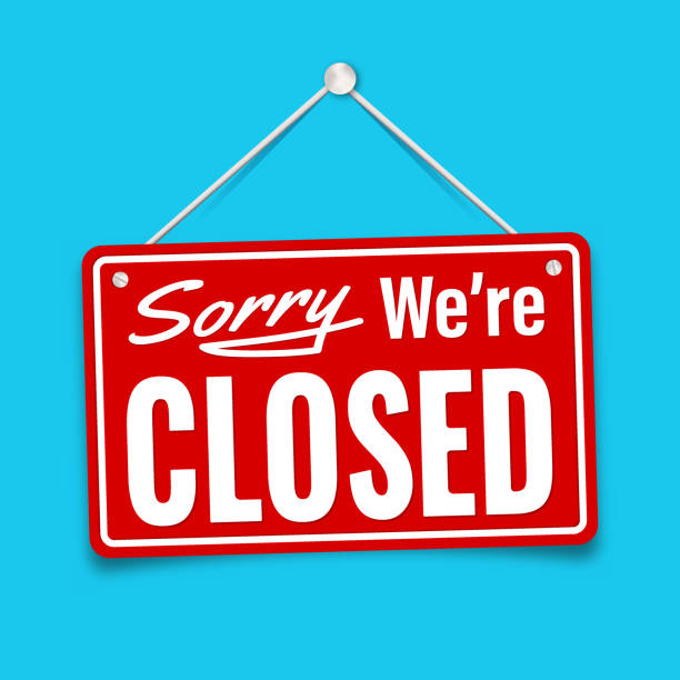 A red rectangular sign hanging by white strings against a bright blue background, reading 'Sorry We're CLOSED' in white text.