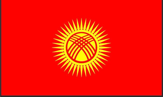 The image displays the national flag of Kyrgyzstan, featuring a red field with a central yellow sun emblem containing a stylized tunduk (the crown of a traditional yurt) surrounded by 40 rays. The flag is referenced in the post to illustrate Kyrgyzstan's parliament approving a Bitcoin reserve bill, highlighting the country's emerging role in the international race to adopt Bitcoin as a national reserve asset.