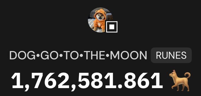 The image features a brown dog wearing an orange hoodie, standing next to a sign that reads "Dog-Go-To-The-Moon Runes 1,732,531,861". The dog appears to be posing for the photo with its tongue out and tail wagging. The background of the image is black, which contrasts nicely with the brown color of the dog's hoodie.
