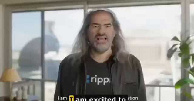 The image features a man with long hair wearing a black jacket, standing in front of a window. The text overlaying the image reads "I am excited to see the future of $XRP." This suggests that the man is enthusiastic about the potential growth and impact of the cryptocurrency market on the future.