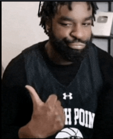 A portrait of a bearded Black man wearing a black 'H Point' basketball jersey giving a thumbs-up gesture, with a YouTube play button visible in the background.