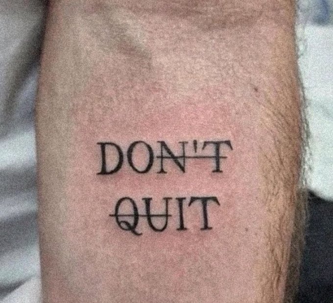 The image features a tattoo of the words "Don't Quit" written in black ink on a person's arm. This quote serves as an inspiration for perseverance, determination, or motivation. The tattoo artist has used a simple yet powerful design that can be easily understood and appreciated by anyone who sees it.
