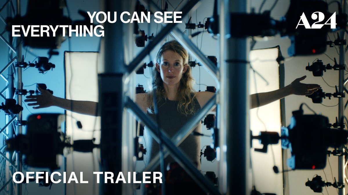 A woman with blonde hair stands in front of a metal rig filled with numerous cameras and lights, with the text 'YOU CAN SEE EVERYTHING', 'OFFICIAL TRAILER', and the 'A24' logo visible on screen.