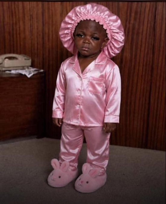 A young child wearing a pink satin pajama set with a matching bonnet and bunny slippers stands against a wood-paneled wall, looking serious for the camera. The image appears unrelated to the post's discussion about Web3, AI, and The ARCTERMINAL platform, serving instead as a cute, contrasting visual to the technical topic.