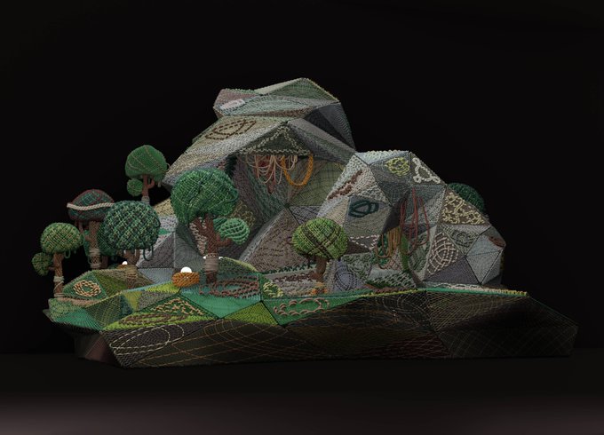A textured 3D diorama displays a stylized landscape with geometric rock formations, embroidered-style green trees, and intricate stitching patterns against a black background.