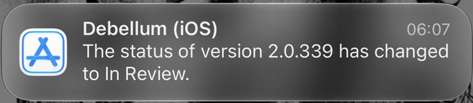 An iOS push notification from the App Store shows that the status of an app called 'Debellum' version 2.0.339 has changed to 'In Review'.