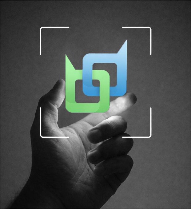 A black and white photograph of a hand reaching out, with a glowing green and blue geometric logo hovering above the palm inside camera viewfinder brackets.