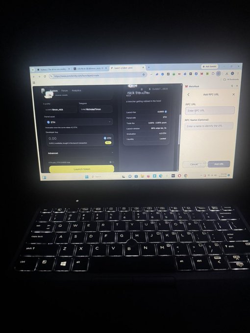 A photograph of a laptop screen in a dark room displaying a 'MicroRoll' token launch interface on a website, with a 'Launch Token' button visible.