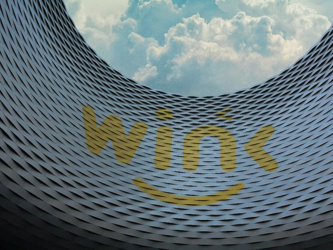 A curved, fish-scale-patterned architectural surface displays the yellow "Wink" logo (stylized with a smile underneath) set against a backdrop of cloudy sky, visually reinforcing the article's point about Wink's role in delivering low-latency infrastructure for high-frequency DeFi perpetual trading on the TRON network.