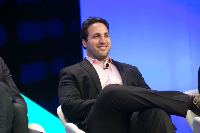 Kyle Samani, the former co-founder and managing partner of Multicoin Capital, sits casually on stage with a smile during what appears to be a conference panel discussion, an image that complements coverage of his public criticism of his former firm and its relationship to the Solana ecosystem.