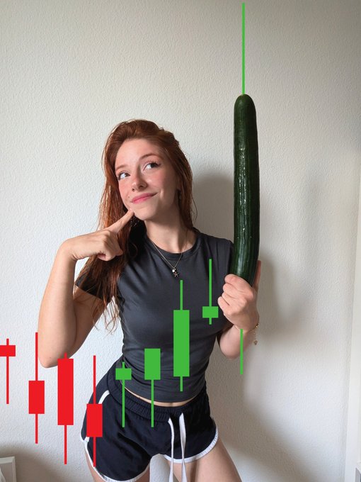 A young woman with red hair points to her cheek while holding a large cucumber, with red and green stock candlestick chart graphics overlaid on the image.