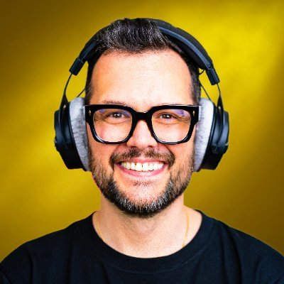 A smiling man with a beard and black glasses wears over-ear headphones against a bright yellow background, matching the promotional image for Maurizio Pedrazzoli Grazioli, host of the Mr. podcast, who is announced as a guest on October 8, 2026, at 3:30 PM Dubai time to discuss Bitcoin.