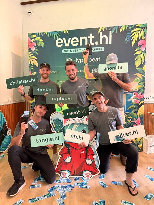 Four men pose playfully at an 'event.hl' promotional booth dated October 7, each holding up green name signs like 'christian.hl', 'tani.hl', 'oliver.hl', and 'yhani.hl'.