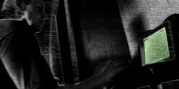 A shadowy hooded figure sits at a glowing green CRT monitor in a dimly lit space, evoking a sense of clandestine digital negotiation. The image visually reinforces the post's theme of disconnected protocol layers, suggesting the @InternetCourt as a cryptic mediator that stitches together the fragmented pieces of agent-driven deals.