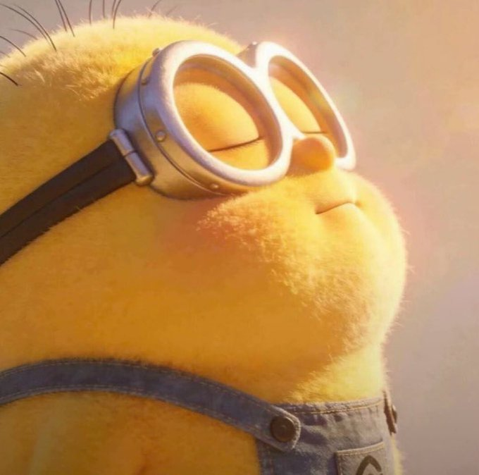 Close-up of a yellow minion character wearing metallic goggles, featuring detailed fur texture and denim overalls.