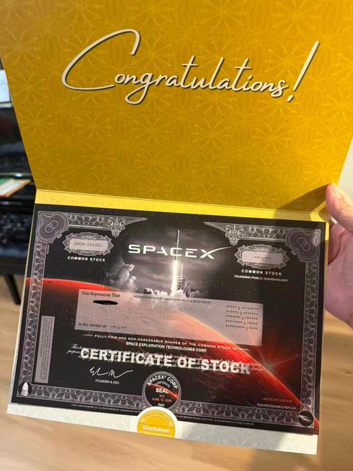 A hand holding open a SpaceX certificate holder displaying a 'Congratulations!' message with a framed Space Exploration Technologies Corp certificate of stock featuring a rocket launch and planetary imagery.