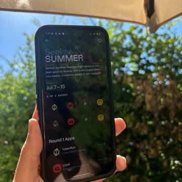 A hand holds up a smartphone displaying the Seeker Summer app screen, which advertises "Seek SUMMER" with dates "Jul 7–15" and highlights "Round 1 Apps" including TokenTuner and Loyee. The screen shows various colorful app icons and rounds, tying into the celebratory post about claiming 8 badges and 3,000 $SKR tokens for Seeker Summer.