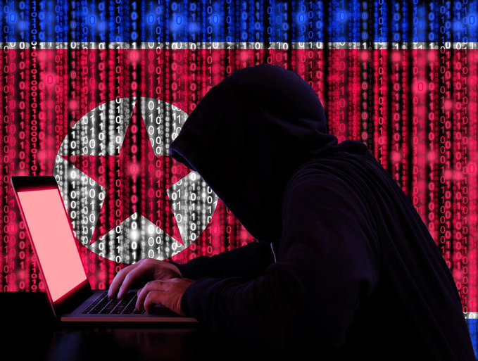 A dramatic illustration of a hooded hacker typing on a laptop, silhouetted against a backdrop of red binary code featuring the North Korean flag emblem.