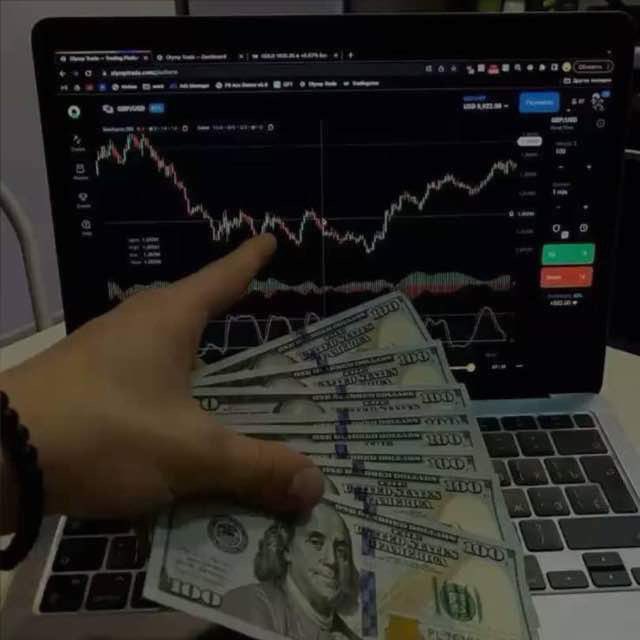 A hand fans out several $100 US bills in front of a laptop displaying a GBP/USD trading chart on what appears to be a cryptocurrency exchange interface, symbolizing the financial incentive and capital at stake that drives trader engagement and retention—visually reinforcing the post's message that real exchange growth comes from giving traders meaningful reasons to try, trade, and return, rather than just loud marketing.