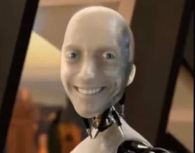 A distorted, smiling humanoid robot or mannequin figure with an exposed metallic neck mechanism, set against an indoor background.