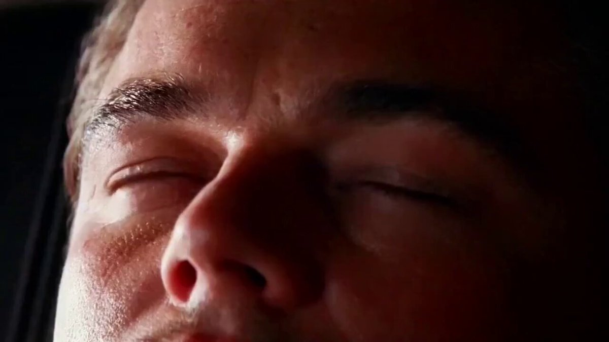 The image features a close-up of a person's face with their eyes closed, as if they are sleeping or resting. They appear to be a man, possibly wearing glasses. The background seems dark, which emphasizes the subject of the picture. The context is unclear from what you can see in the image itself, but it could potentially be related to an advertisement for Bitcoin or a discussion about the crypto currency market.