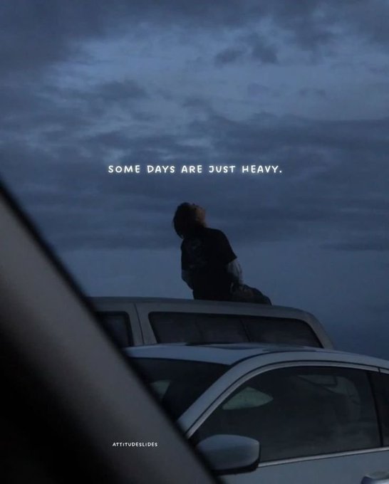 A silhouette of a person sitting on top of a car against a dark, cloudy sky, featuring the text 'SOME DAYS ARE JUST HEAVY.' and a watermark 'ATTITUDESLIDES'.