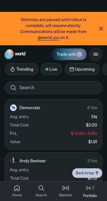 The image shows the World (formerly Worldcoin) app's portfolio screen, which supports the tweet announcing that Stimmies (incentives) are paused during rollout but will resume soon, with communications handled on X via @world_xyz. Visible are active prediction market positions including "Democrats" (4 Yes, down 4.6% with a -$0.09 PnL) and "Andy Beshear" (3 Yes), alongside navigation tabs for Trending, Live, and Upcoming markets.