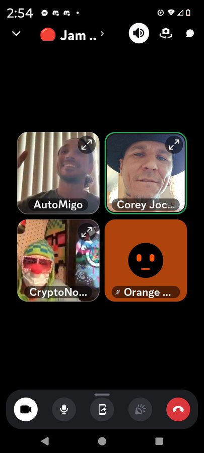 A mobile video call interface showing four participant tiles: AutoMigo, Corey Joc..., CryptoNo..., and Orange..., with active call controls at the bottom.
