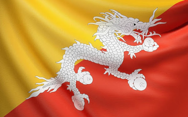 The image shows the flag of Bhutan, featuring its distinctive yellow and orange halves divided diagonally, with a white dragon clutching jewels in the center. This relates to the news about Bhutan transferring approximately 10.779 BTC (worth around $835K) to two new addresses, as the country is known to hold significant Bitcoin reserves mined from its renewable energy-powered operations.