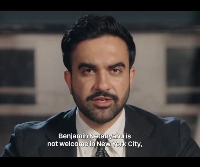 A man in a suit appears in what looks like an interview setting with the caption "Benjamin Netanyahu is not welcome in New York City."