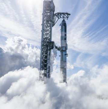 A photograph of a SpaceX rocket and launch tower seen above the clouds from a high altitude.