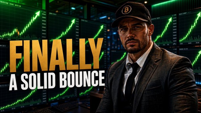 A man wearing a Bitcoin logo cap and suit sits in front of multiple screens displaying green upward-trending BTC price charts, with bold text reading "FINALLY A SOLID BOUNCE"—promoting a Bitcoin market analysis video. The visual emphasizes a positive reversal in BTC's price action, aligning with the post's call to check the previous day's Bitcoin update video.