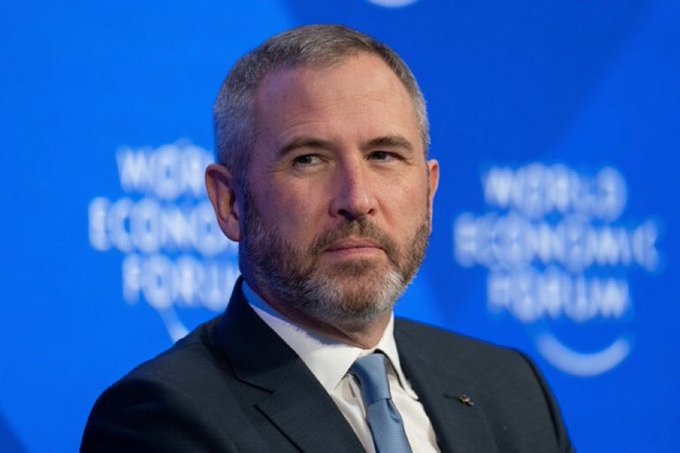 Ripple CEO Brad Garlinghouse is pictured at the World Economic Forum, against a blue backdrop displaying the "World Economic Forum" branding. The image accompanies news that Ripple has secured full MiCA approval, enabling the company to offer regulated crypto services across the EEA and expand banking, fintech, and enterprise offerings.