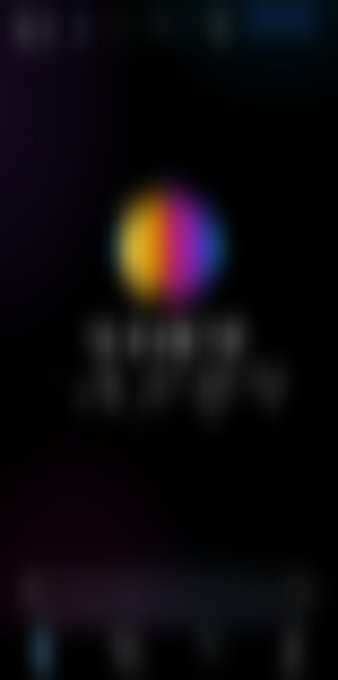 A heavily blurred dark image showing an indistinct colorful circular graphic with unreadable text underneath.