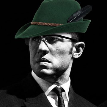 A black-and-white vintage photograph of a man in a suit and glasses has been humorously edited with a green Tyrolean hat featuring a feather, fitting the social media post's playful tone about developing creative ideas and building community momentum for the meme tokens $MEOWOOD and $JUGGERNAUT.