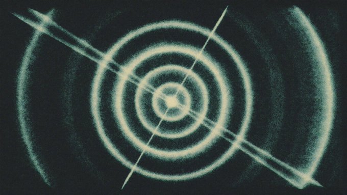 A bright target-like pattern of concentric glowing rings with diagonal crosshairs pierces the center, set against a dark background and flanked by curved arcs, visually symbolizing precision targeting or focused tracking of a specific data point. The image evokes the act of "tracking" a single growing segment amid a broader landscape—much like Olaniyi's focus on sports betting driving prediction market growth from 40% to 81% of Polymarket volume in Q2.