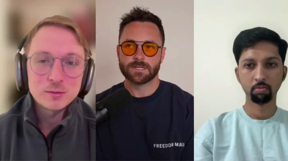 The image shows three men wearing headphones, each with a different expression as they look into the camera. They are positioned behind microphones, suggesting that they might be participating in an interview or a podcast recording session. The background of the image features a white wall, which contrasts with the colorful and lively expressions on the faces of the men.