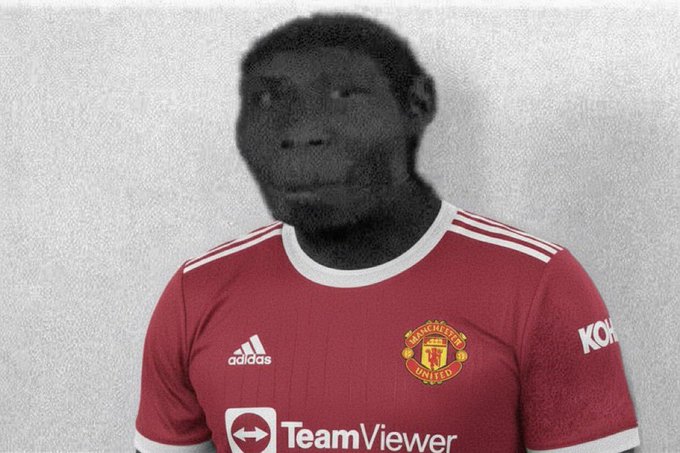 A man wearing a Manchester United home kit with the TeamViewer sponsor logo on a light gray background.